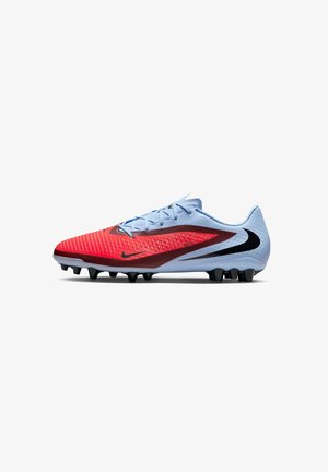 Crampon de football avec l'avant texturé rouge, tige bleu clair, logo Nike noir et crampons noirs sur fond blanc.