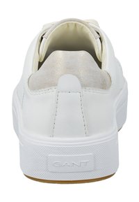 Baskets en cuir blanc avec une semelle en caoutchouc blanc texturé. Présente un accent doux et brillant au talon ainsi qu'un logo de marque à l'arrière.