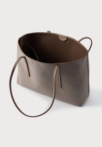 Pruunist kott, millel on geomeetriline tekstuur, siledast nahast käepidemed, avatud sisemus ja kontrastne pruun vooder. Nähtavad riistvara detailid puuduvad.