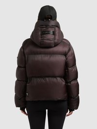Puffer jacket in deep burgundy, featuring a high collar, visible stitching, and a textured finish. Includes a logo patch on the back.