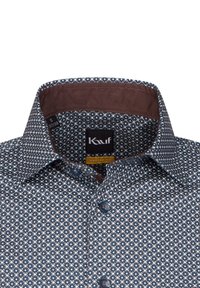 Camicia a fantasia blu con colletto marrone scuro, caratterizzata da un piccolo motivo floreale, bottoni in blu coordinato e un'etichetta che indica la taglia S.