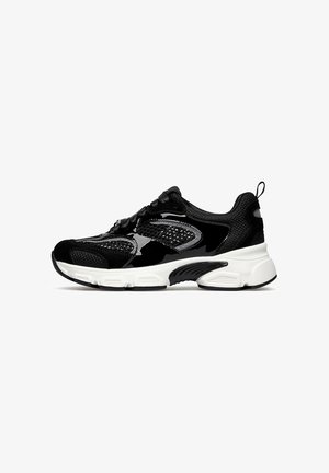 Sneaker sportiva nera con pannelli in mesh e lucidi, suola bianca spessa, design con lacci e linguetta sul tallone.