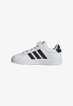 Biały sneaker Adidas z czarnymi paskami, białymi sznurowadłami i rzepem, widoczny od wewnętrznej strony na białym tle.