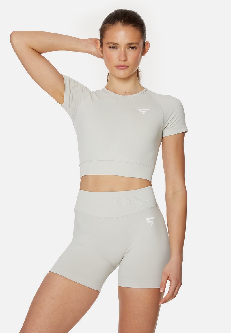 Light gray athletic set featuring a cropped top and high-waisted shorts. The material is smooth with minimal stitching and a white logo accent.