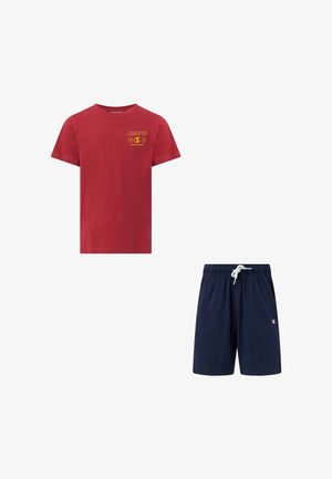T-shirt rouge à manches courtes avec logo Champion jaune et short à cordon de serrage bleu marine avec petit emblème Champion sur la jambe gauche.