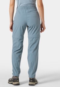 Vaaleansiniset ulkohousut, joissa on joustava vyötärönauha, irrotettavat lahkeet ja sileä pinta. Varustettu vahvistetuilla saumoilla ja käytännöllisillä taskuilla.