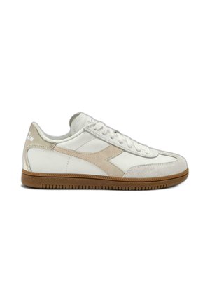 White and beige low-top sneaker with suede details, lace-up design, and gum rubber sole on a white background.