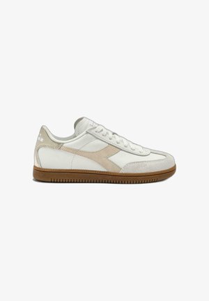 White and beige low-top sneaker with suede details, lace-up design, and gum rubber sole on a white background.