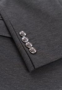 Dunkelgraue Anzugjacke mit Ärmeln, die vier Knöpfe mit strukturierter Oberfläche aufweisen, akzentuiert durch dezente Nähte am Rand.