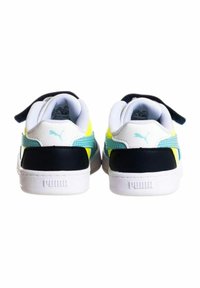 Zapatillas Puma con un diseño en blanco, negro y amarillo. Presentan un material suave, un cuello acolchado y acentos texturizados en turquesa.
