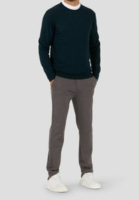 Marineblauwe trui met een ronde hals, gecombineerd met grijze tapered pants en witte sneakers. Zachte stof met ribgebreide manchetten en tailleband.