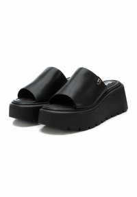 Chanclas de plataforma negras con un diseño de punta abierta. Parte superior de imitación cuero suave, suela gruesa estriada y un sutil detalle de la marca en la correa.