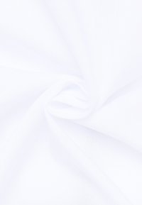 Tessuto bianco con una superficie liscia e leggermente strutturata, che mostra pieghe delicate che suggeriscono flessibilità e morbidezza.