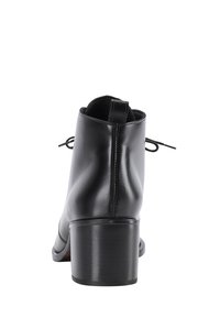 Bocanci negri din piele pentru gleznă, cu o finisare netedă, vârf rotunjit și toc pătrat. Au sireturi subțiri și o bucată pentru prinderea tocului. Design minimalist.