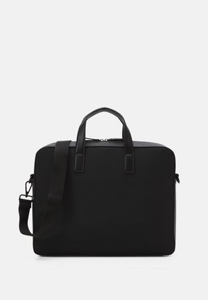 Sac rectangulaire noir avec deux poignées supérieures et une bandoulière réglable. Fabriqué en matériau lisse avec un design minimaliste.