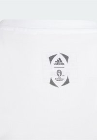 Camiseta de algodón blanca con un logotipo negro de adidas y un parche de la UEFA Euro 2024 en la parte de atrás. Incluye detalle de cuello acanalado.