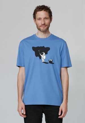 Blauwe katoenen t-shirt met een zwarte afbeelding van een astronaut die een sterrenhemel schildert met een emmer. Korte mouwen en ronde hals.