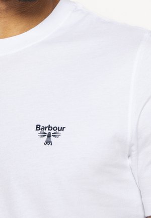 Hvid T-shirt med lille sort "Barbour"-logo og fyrtårnsillustration på øverste venstre brystområde.