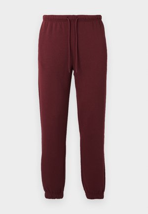 Pantaloni de jogging burgundy, confecționați dintr-un material moale, cu talie elastică, șnur ajustabil și manșete conice pentru o potrivire strânsă.