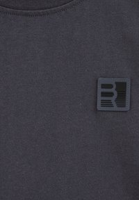 Țesătură gri închis cu un logo pătrat cusut, negru și gri, prezentând linii și forme orizontale abstracte în partea superioară stângă.