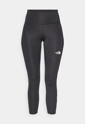 Augsta vidukļa melnas legingi no elastīga auduma. Kreisajā augšstilbā balts logotips un plakanās šuves ērtībai.