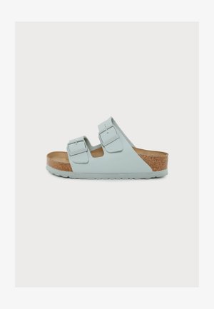 Lyseblå sandal med åben tå med to justerbare remme og spænder, korkindlæg og gummisål.