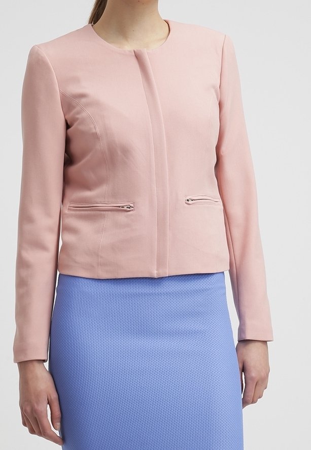 Kort rosa kavaj med rund halsringning, figursytt snitt och två framfickor med dragkedja; bärs över en strukturerad ljusblå kjol.