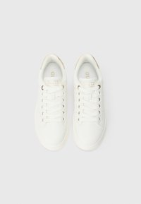 Sneakers bianche con tomaia liscia simile alla pelle, occhielli color oro e dettaglio testurizzato sul tallone. Include lacci piatti e branding discreto.