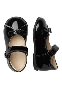 Zapatos Mary Jane de charol negro con punta redondeada, correa ajustable y un lazo en la parte delantera. Forro interior suave.