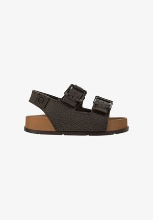 Sandalo marrone scuro con due cinturini regolabili con fibbia e suola imbottita color cuoio su sfondo bianco.