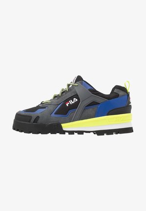 Zapatilla Fila de caña baja con paneles negros, grises y azules, suela y cordones de color amarillo neón, y una suela exterior negra resistente.