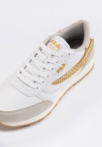 Baskets blanches avec détails dorés, maille texturée et détails en daim. Dotées d'un bout arrondi, de lacets plats et d'une semelle extérieure en caoutchouc avec motif de crampons.