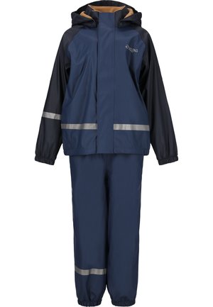Completo impermeabile blu navy con strisce riflettenti grigie. La giacca presenta un cappuccio e polsini elasticizzati; i pantaloni hanno una vita e polsini elasticizzati.