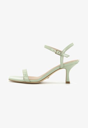 Sandali con tacco in pelle verniciata verde menta, con punta quadrata, sottile cinturino alla caviglia e tacco affusolato. Caratterizzati da una texture liscia e un design minimal.