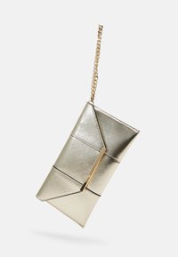 Metallisk gullhåndveske med geometrisk design, teksturert overflate og en gullkjede-stropp. Har en elegant metallspenne for lukking.