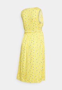 Vestido amarelo floral com um design sem mangas, cintura franzida e cinto. Apresenta um padrão de pequenas flores brancas e folhas verdes.