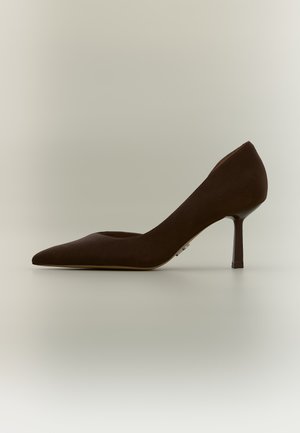 Escarpin en daim marron à bout pointu avec un talon moyen et fin sur un fond neutre.
