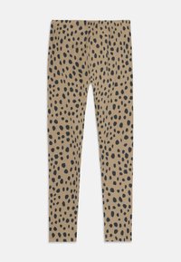 Leggings di colore beige con un motivo a macchie nere. Realizzati in un materiale morbido con un design aderente e elasticizzato e una vita elastica.