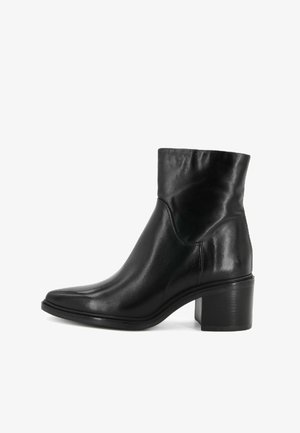 Bottine en cuir noir avec un bout pointu, un talon bloc de hauteur intermédiaire et un matériau supérieur légèrement plissé pour une texture supplémentaire.