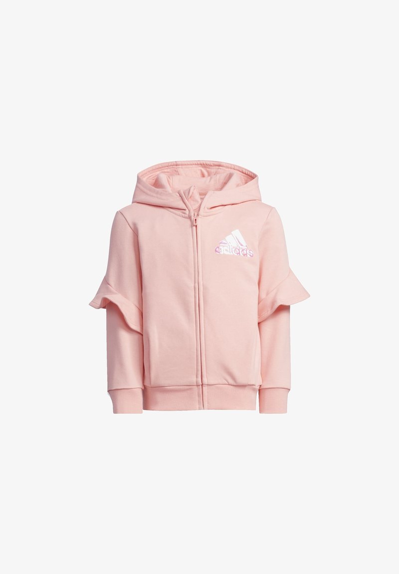 Růžová mikina s kapucí a volánovými rukávy, se zipem a bílým logem Adidas na hrudi. Vyrobena z měkkého, strukturovaného materiálu.