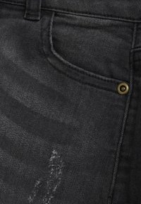 Svarta denimjeans med ett subtilt slitet mönster, med en framficka och detaljer i guldfärgade nitar. Slät textur och klassisk design.