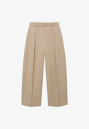 Un pantalon large beige suspendu verticalement, avec des plis avant et une taille plate, mettant en avant un style neutre et élégant.