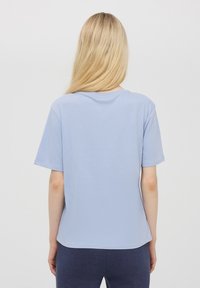 T-shirt di cotone azzurro chiaro con maniche corte, scollo rotondo e vestibilità rilassata. Texture morbida senza motivi o accentuazioni visibili.