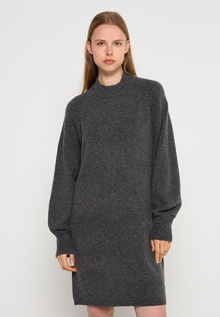 Graues gestricktes Kleid mit hohem Kragen und langen Ballonärmeln, das eine lockere Form und einen strukturierten Stoff aufweist. Minimalistisches Design, keine sichtbaren Muster.