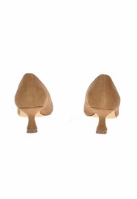 Scarpe con tacco alto in suede marrone, con punta affilata e tacco sottile, caratterizzate da una texture liscia e un design minimal.