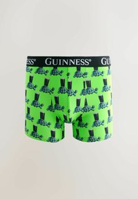 Hellegrüne Boxershorts mit sich wiederholendem Schildkrötenmuster, die Pints Guinness tragen, und schwarzer Bund mit weißem Guinness-Logo.