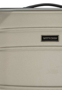 Maleta Wittchen en material texturizado de color beige claro, con una superficie lisa, líneas horizontales y una placa con el logo en negro.