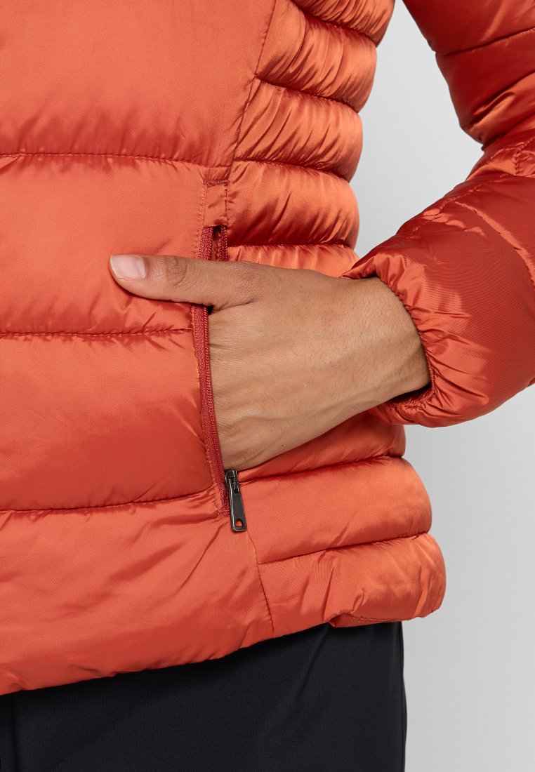 Rote Pufferjacke mit gestepptem Muster und einem Reißverschlussfach an der Seite. Das Material ist glatt und glänzend, was einen eleganten Look verleiht.