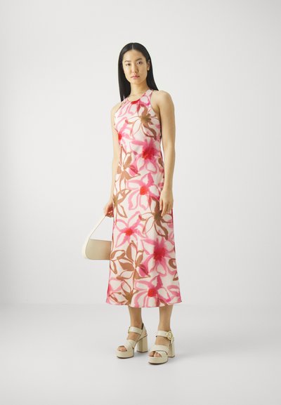 Abito maxi a fantasia floreale con tonalità di rosa e marrone, senza maniche e con una leggera lucentezza. Abbinato a scarpe con plateau bianche e una morbida borsa beige.
