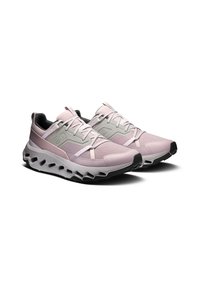 Baskets de sport rose clair avec des accents gris, dessus en maille respirante, semelle épaisse blanche avec une base noire, arborant un design de semelle distinctive en vagues.